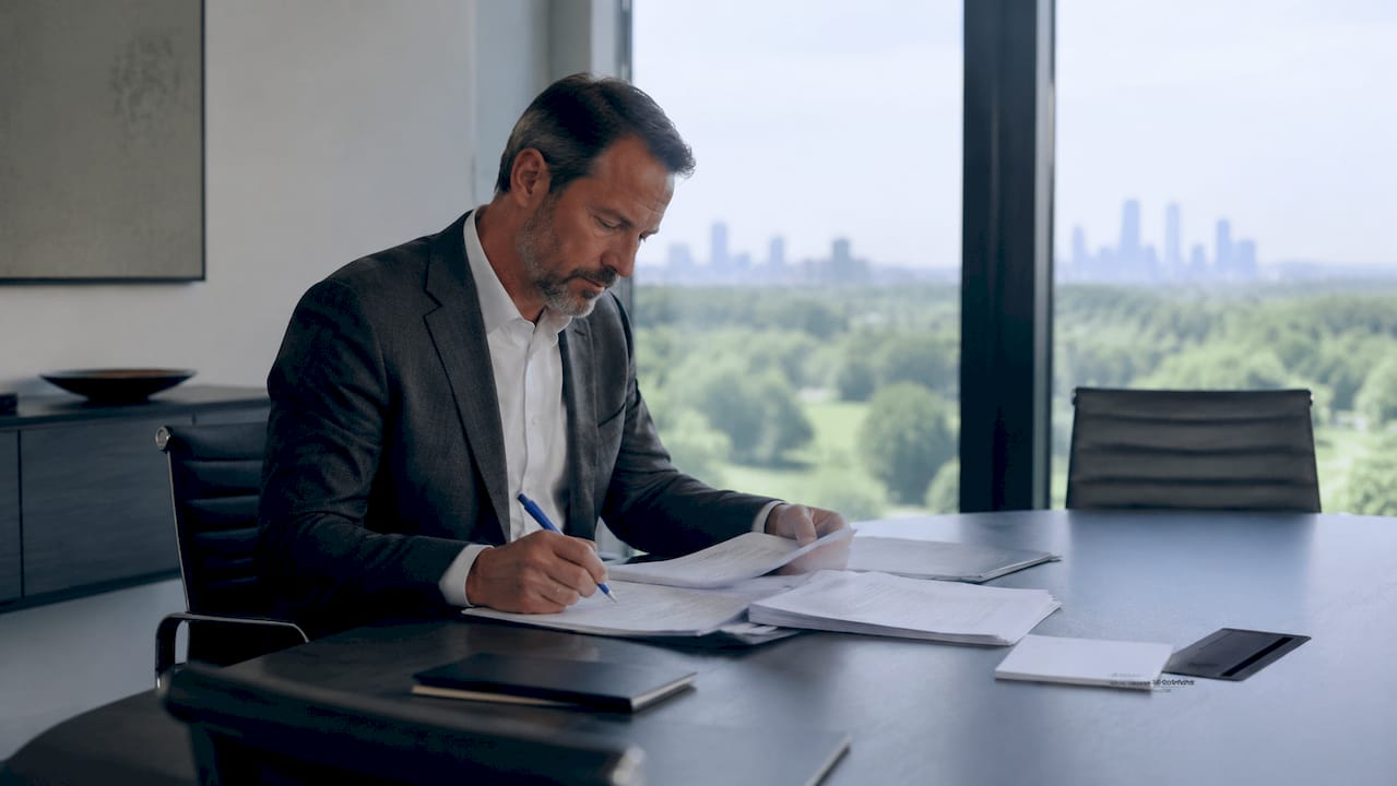 Ein Mann sitzt an seinem Schreibtisch und prüft die aktuellen Bestimmungen des AÜG.
