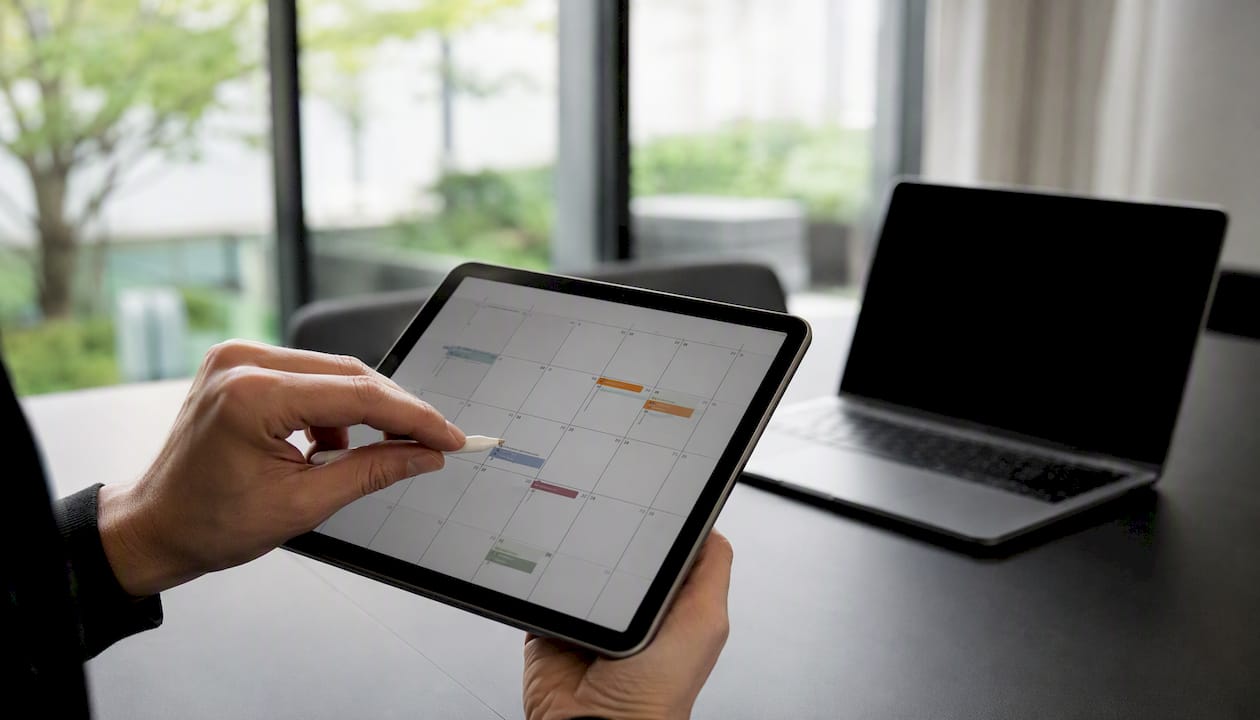Mit einer Hand werden am Tablet wichtige digitale Fristen kontrolliert.