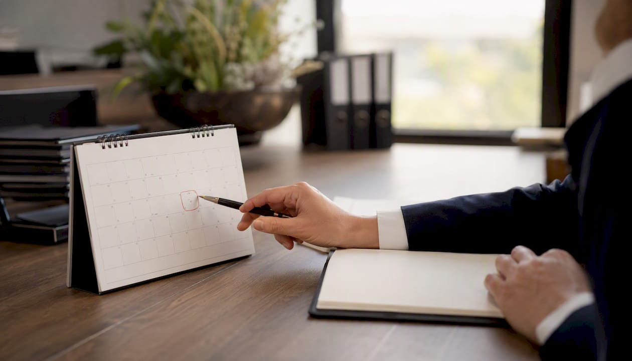 Hand trägt Fristen im Kalender ein